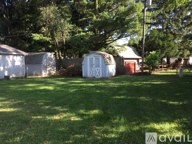 A grassy field with a shed and a fence.
