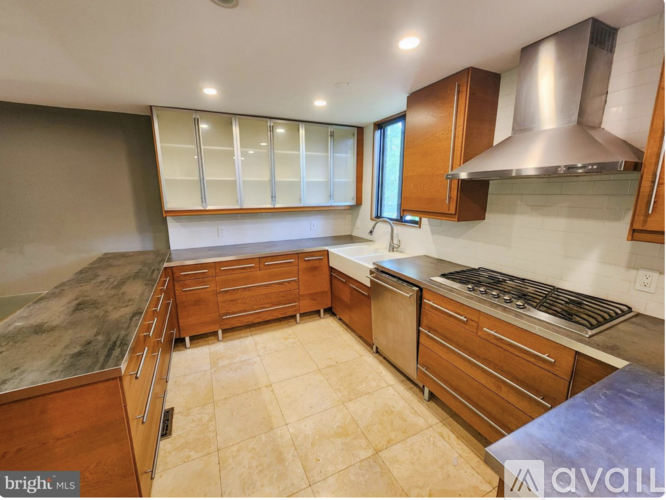 A kitchen with wooden cabinets and a stainless steel range hood.