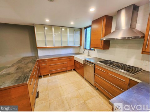 A kitchen with wooden cabinets and a stainless steel range hood.