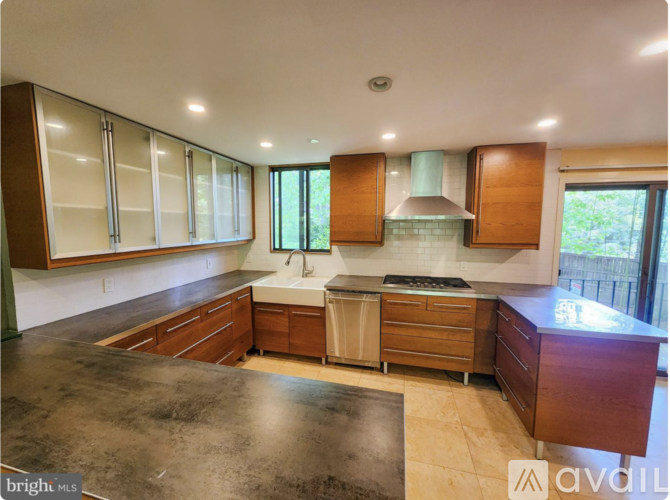A kitchen with wooden cabinets and a black countertop.