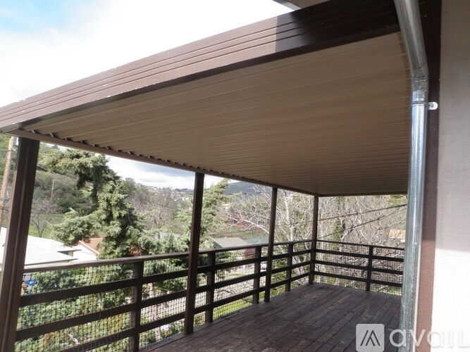 A balcony with a metal railing and a wooden floor.