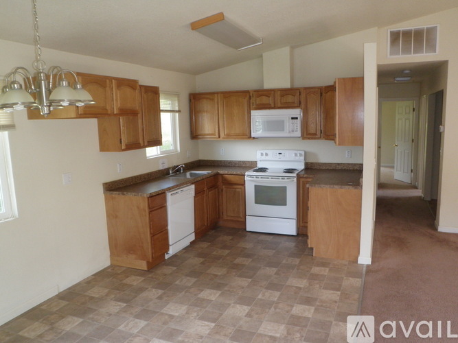 A kitchen with wooden cabinets and a white stove top oven.