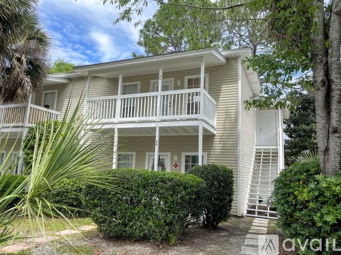 A two-story house with a balcony and a white door.