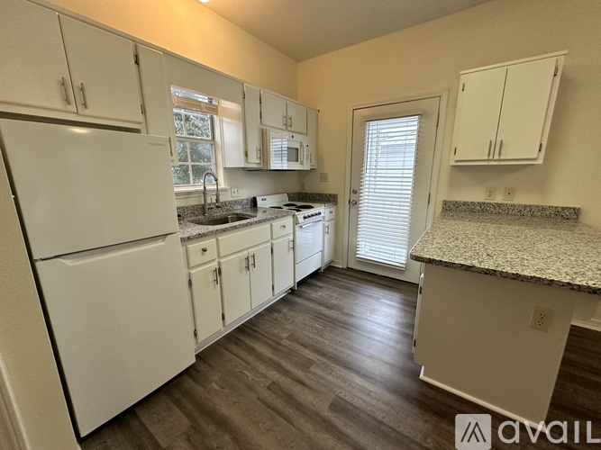 A kitchen with white appliances and cabinets.