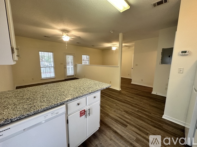 A kitchen with granite countertops and white cabinets.