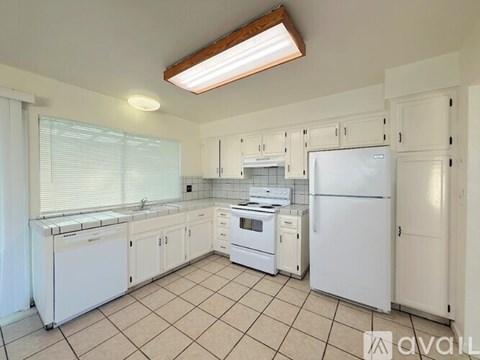 A kitchen with white appliances and cabinets.