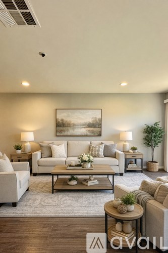 A living room with a couch, a coffee table, and a painting on the wall.