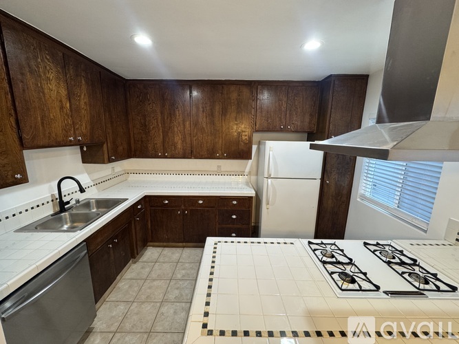 A kitchen with a stove top oven and a dishwasher.