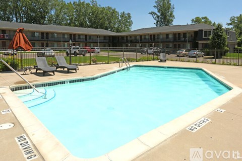 A large outdoor swimming pool with a diving board and lounge chairs.