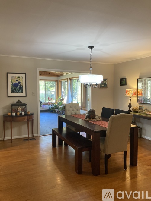 A dining room with a wooden table and chairs.