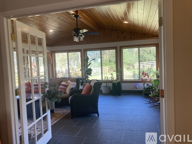 A living room with a ceiling fan and sliding glass doors.