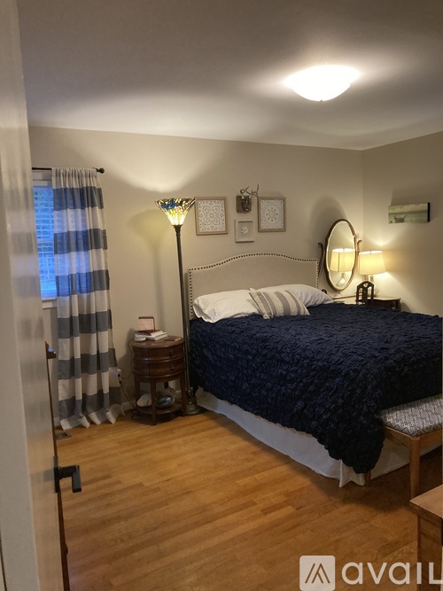 A bedroom with a bed, nightstand, and lamp.