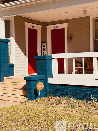 A red door with a white frame and a sign that says "Welcome".
