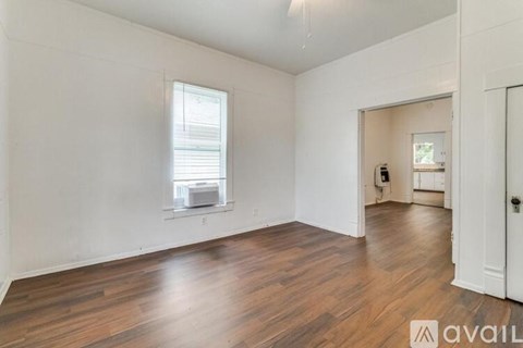 A room with wooden floors and white walls is available for rent.