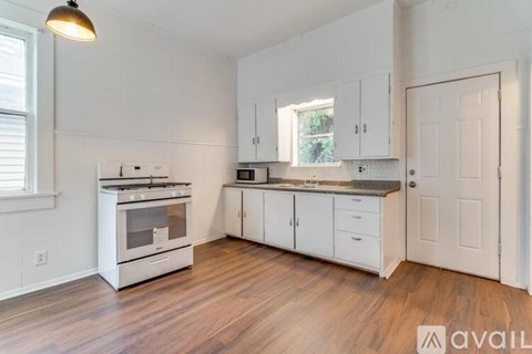 A kitchen with white cabinets and a stainless steel oven.