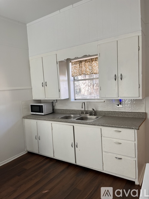 A kitchen with white cabinets and a granite countertop.