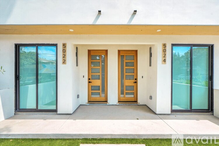 A modern house with a white exterior and a wooden front door.