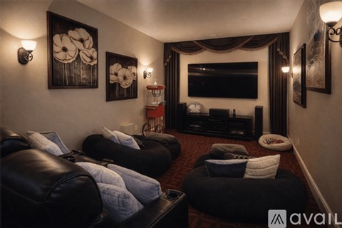 A living room with black leather couches and a flat screen TV.