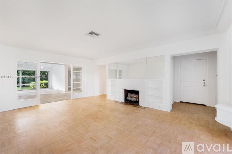 A spacious living room with a fireplace and wooden flooring.