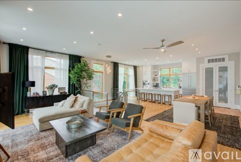 A spacious living room with a variety of furniture and a large window.