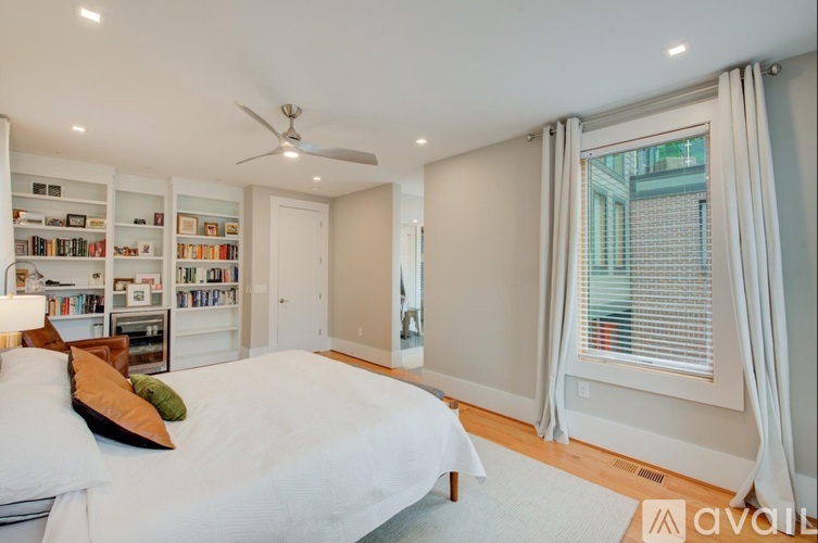 A bedroom with a large bed and a ceiling fan.