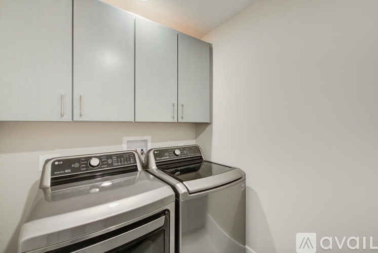 A kitchen with two stainless steel ovens and white cabinets.
