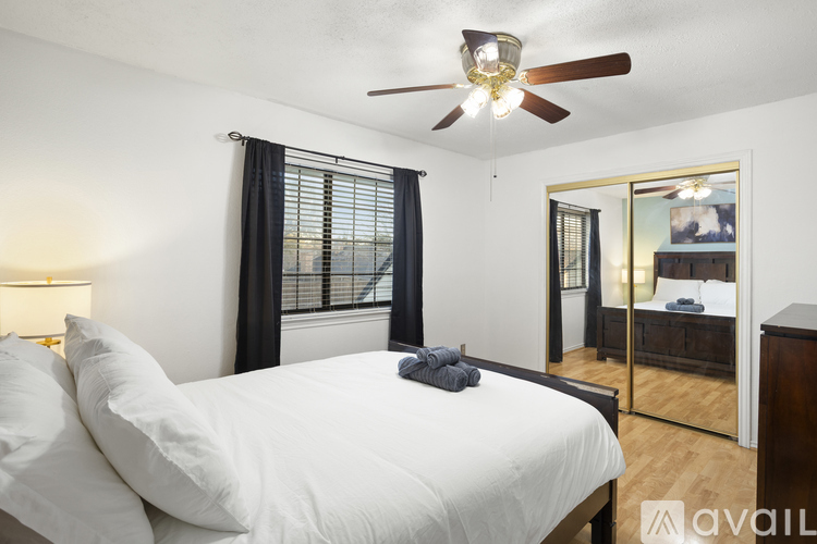 A bedroom with a large bed and a ceiling fan.