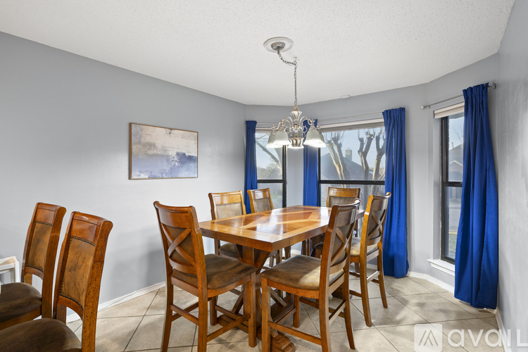 A dining room with a wooden table and chairs.