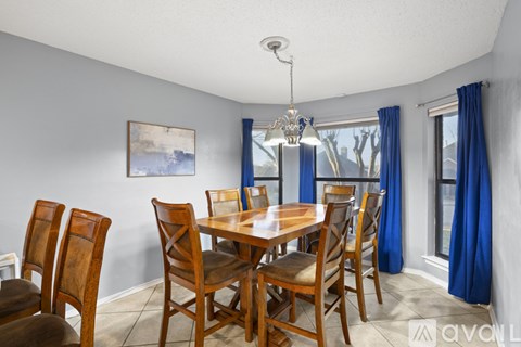 A dining room with a wooden table and chairs.