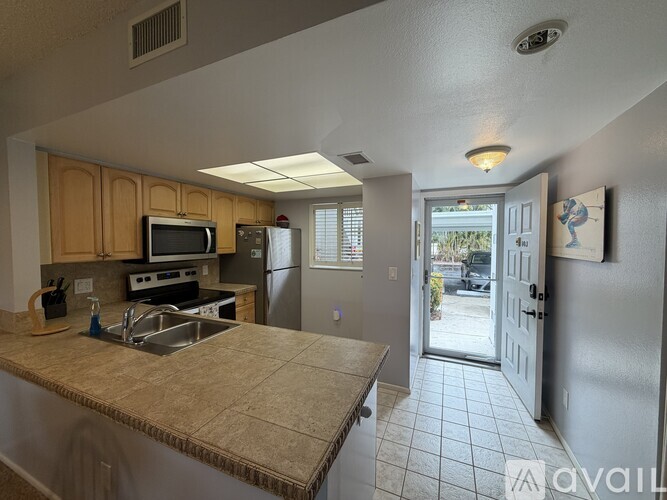 A kitchen with a sink, stove, and refrigerator.