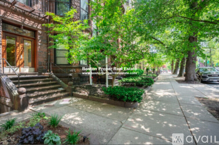 A tree-lined street with a house on the left.