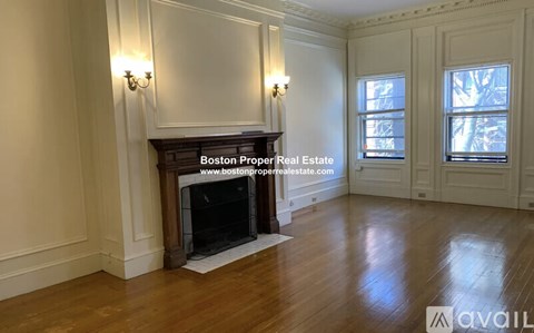 A spacious room with a fireplace and wood flooring.