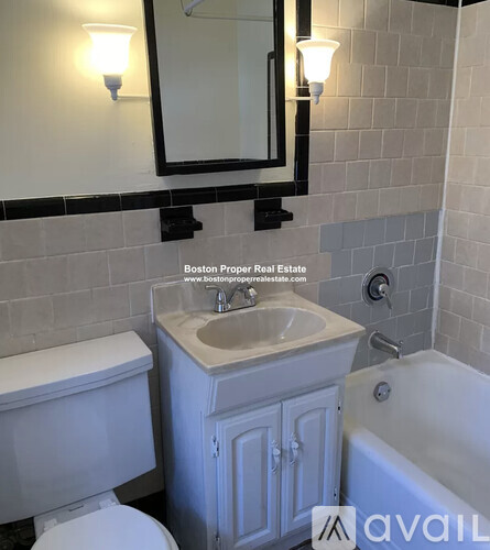 A bathroom with a toilet, sink, and mirror.
