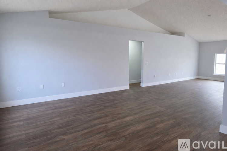 A room with wooden flooring and white walls is available for rent or sale.