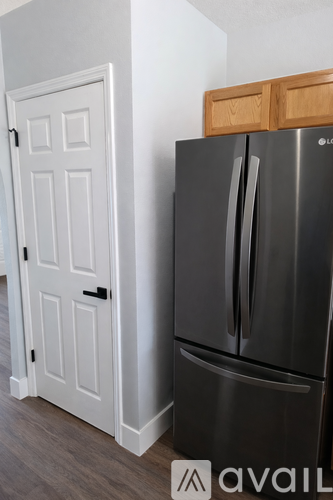 A black fridge with a white door next to it.