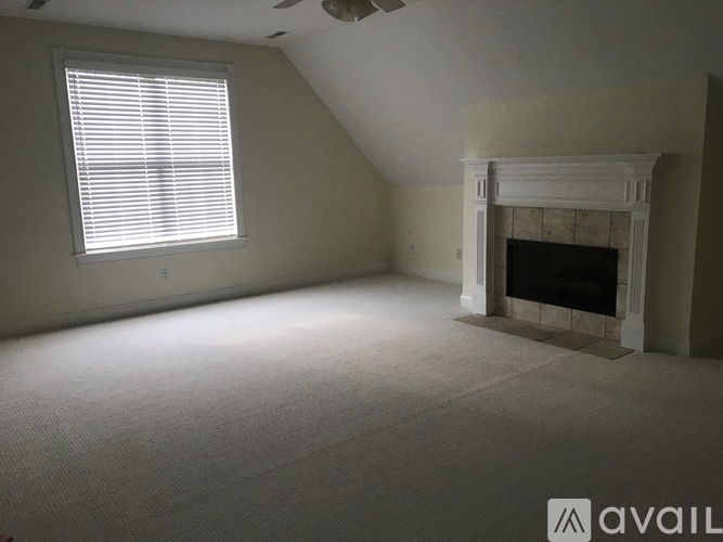 A room with a fireplace and a window with blinds.