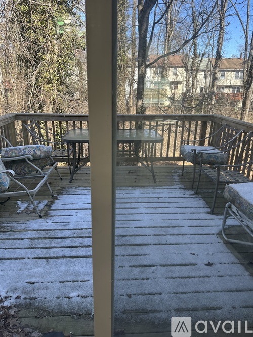 A deck with chairs and a table covered in snow.