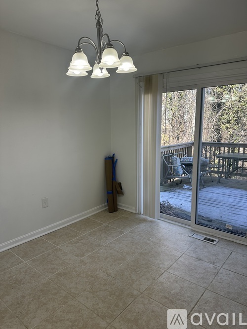 A room with a tiled floor and a sliding glass door leading to a deck.