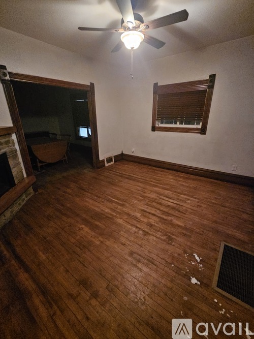 A room with wooden flooring and a ceiling fan.
