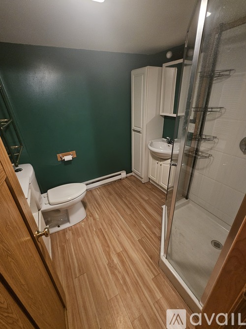 A bathroom with a toilet, sink, and shower.