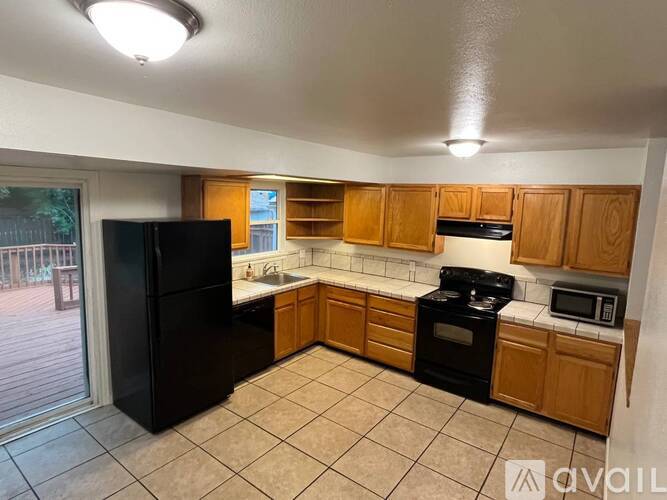 A kitchen with black appliances and wooden cabinets.