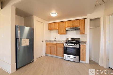 A kitchen with wooden cabinets and a stainless steel refrigerator.