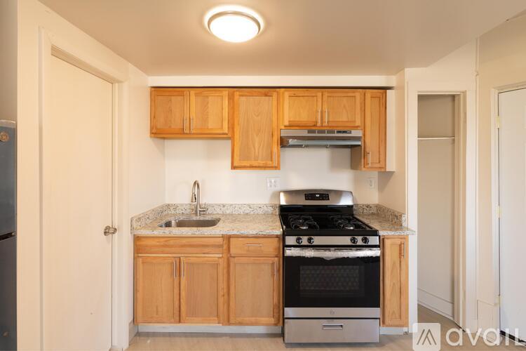 A kitchen with wooden cabinets and a stove top oven.