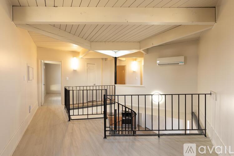 A spacious room with a balcony and a staircase.