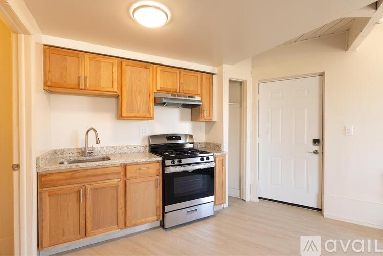 A kitchen with wooden cabinets and a stove top oven.