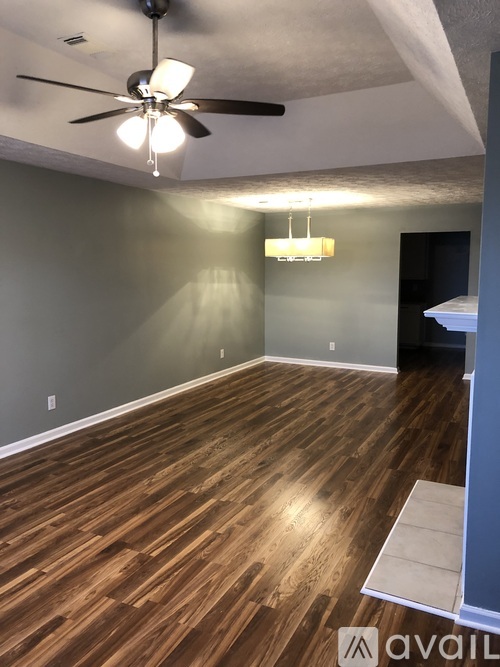 A room with a ceiling fan and a chandelier.