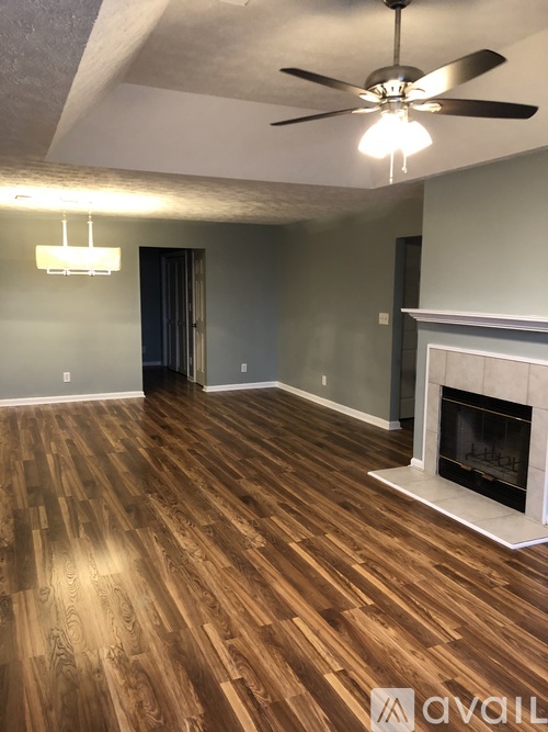 A room with wooden flooring and a ceiling fan.