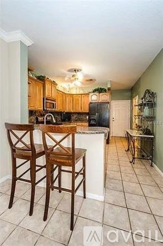 A kitchen with wooden chairs and a counter.