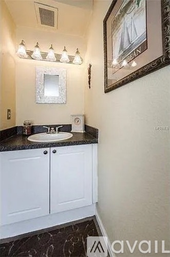 A bathroom with a sink, mirror, and cabinet.