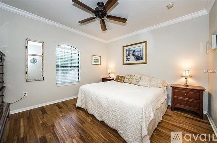 A bedroom with a bed, dresser, and a ceiling fan.